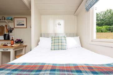 The comfy double bed is tucked away at one end of the hut.