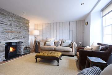 The lovely sitting-room has reclaimed wooden wall panelling and an original stone fireplace.