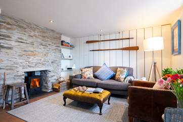 The sitting-room has reclaimed wooden wall panelling and an original stone fireplace with a cosy woodburner.