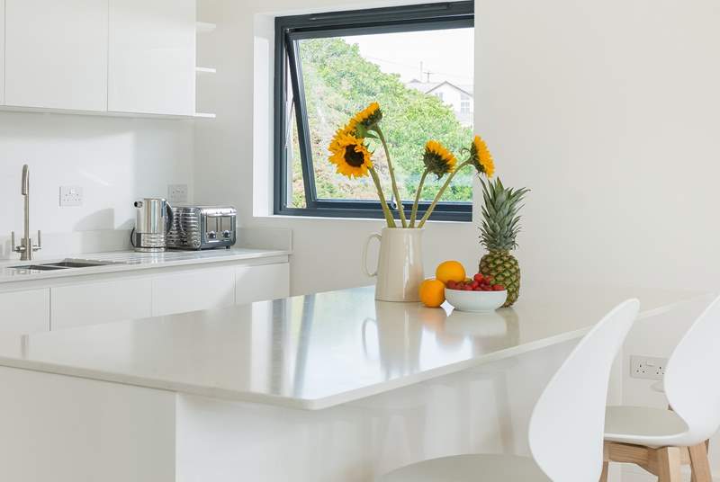 The sleek white marble topped kitchen units are not only practical but rather gorgeous too.