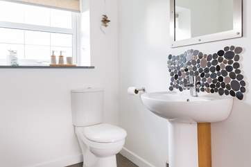 Little pebble tiles add a touch of seaside charm in the bathroom.