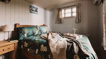 Warm and welcoming, the beautifully furnished main bedroom hosts a sumptuous double bed. 