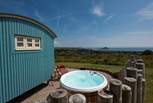 The hot tub sits behind the fence for privacy and shelter and, just like the hut, looks straight out to sea.