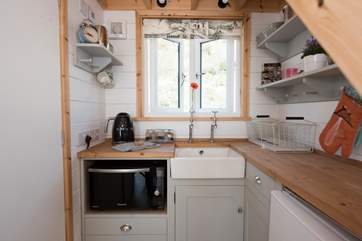 The bijou kitchen is tucked beneath the stairs to the sleeping shelf.
