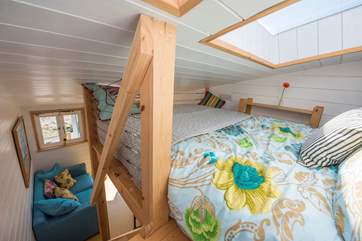 A view from the sleeping-area down the stairs, a little rack and basket are perfect storage for a book and your phone.