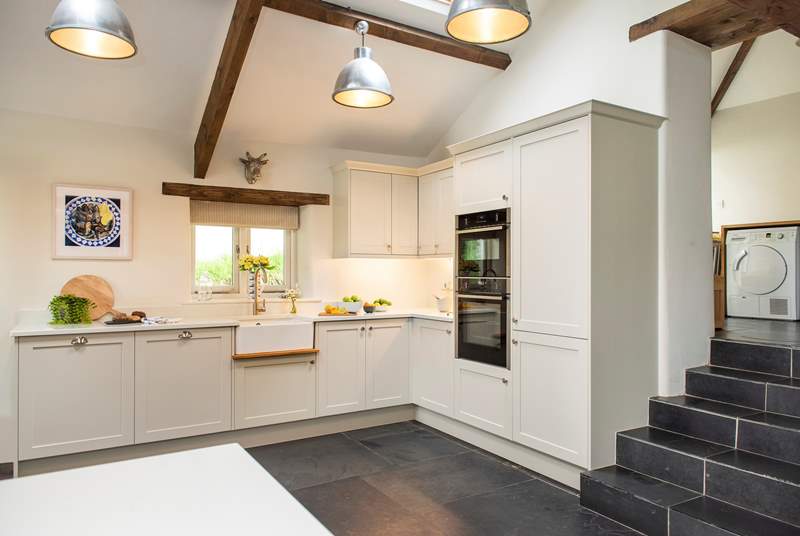 Th stylish kitchen is a welcome sight to walk into. From the kitchen steps lead up to the laundry-room and cloakroom.