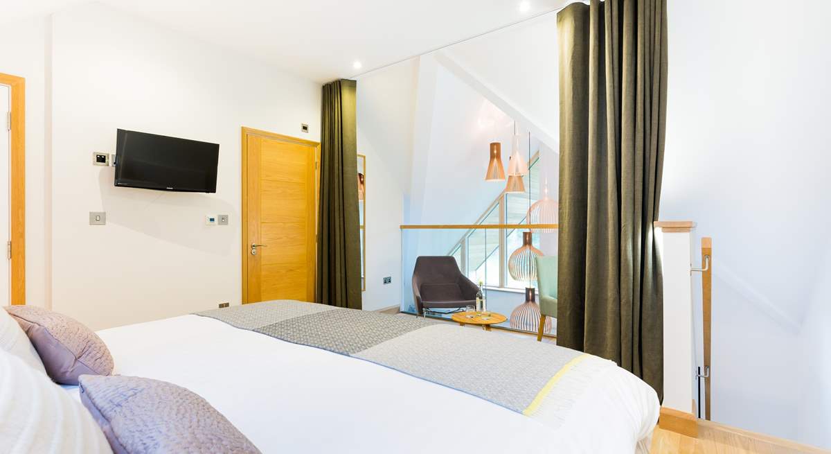 The galleried master bedroom on the top floor overlooks the living space on the first floor. There is a lovely dressing-room next door and an en suite shower-room.