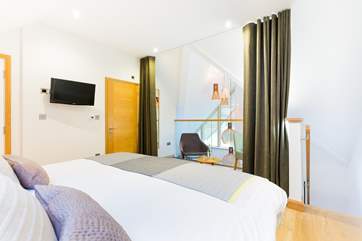 The galleried master bedroom on the top floor overlooks the living space on the first floor. There is a lovely dressing-room next door and an en suite shower-room.