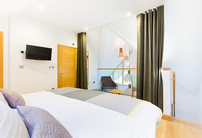 The galleried master bedroom on the top floor overlooks the living space on the first floor. There is a lovely dressing-room next door and an en suite shower-room.