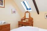 The main bedroom with dressing table and Velux window allowing light and air into the room.