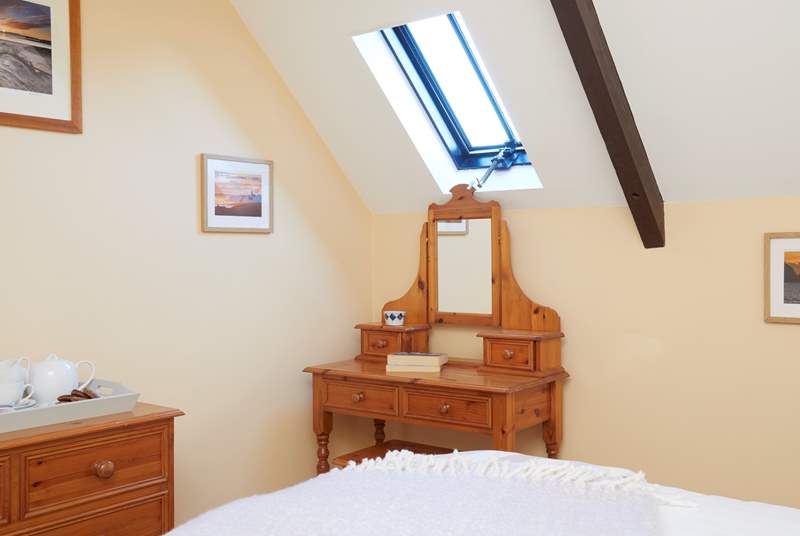The main bedroom with dressing table and Velux window allowing light and air into the room.