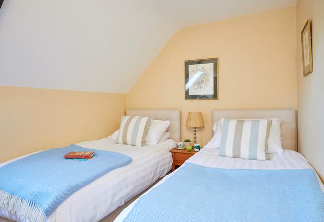 The twin bedroom is charming with its slope ceiling and Velux window allowing in the light.