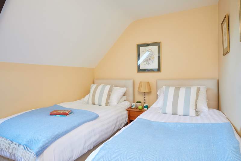 The twin bedroom is charming with its slope ceiling and Velux window allowing in the light.