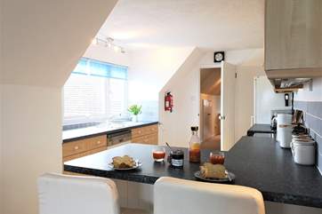 The open plan living-room with kitchen and dining area is beautifully equipped.