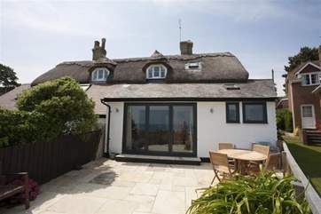 The rear view of this pretty cottage is so inviting.