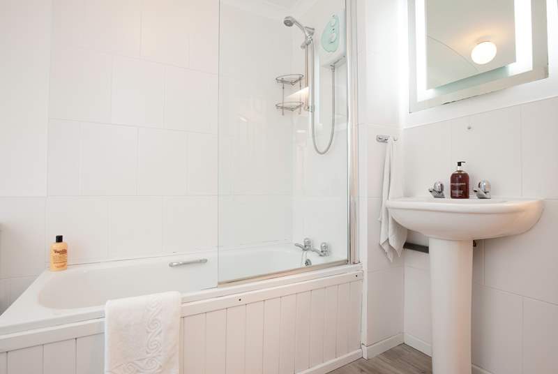 The modern bathroom features a shower over a bathtub.