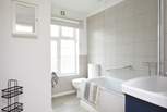 The modern bathroom features a shower over a bathtub.