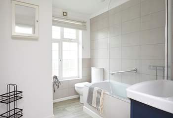 The modern bathroom features a shower over a bathtub.