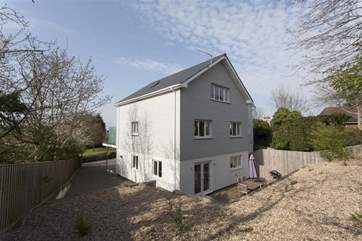 There is rear decking with garden furniture, enclosed by a raised shingle area.