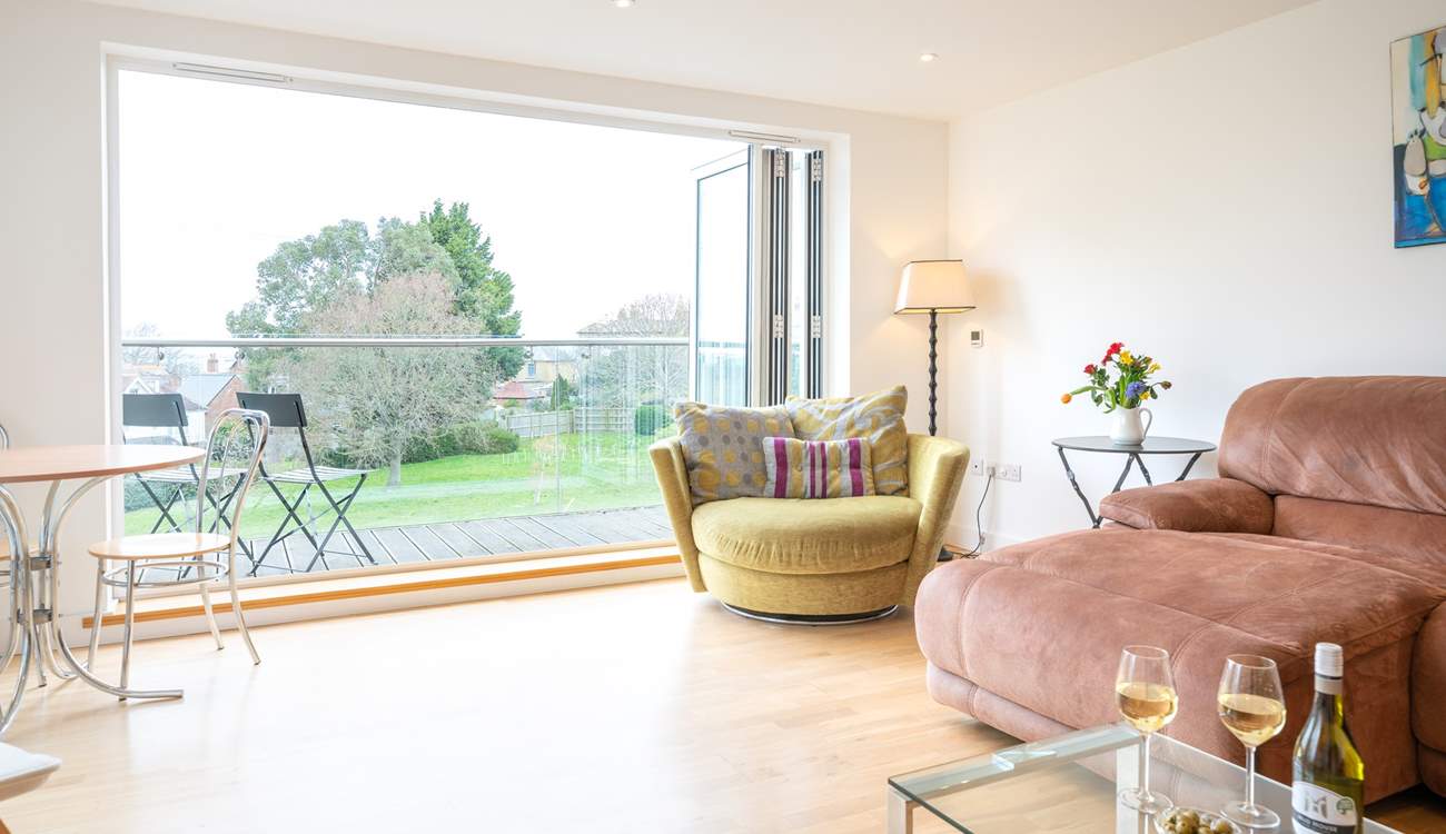 The spacious sitting-room on the first floor with generous seating, has doors leading to a large decked balcony.