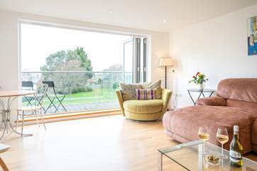 The spacious sitting-room on the first floor with generous seating, has doors leading to a large decked balcony.