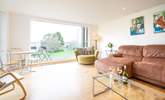 The spacious sitting-room, with generous seating, has doors leading to a large decked balcony. - Thumbnail Image