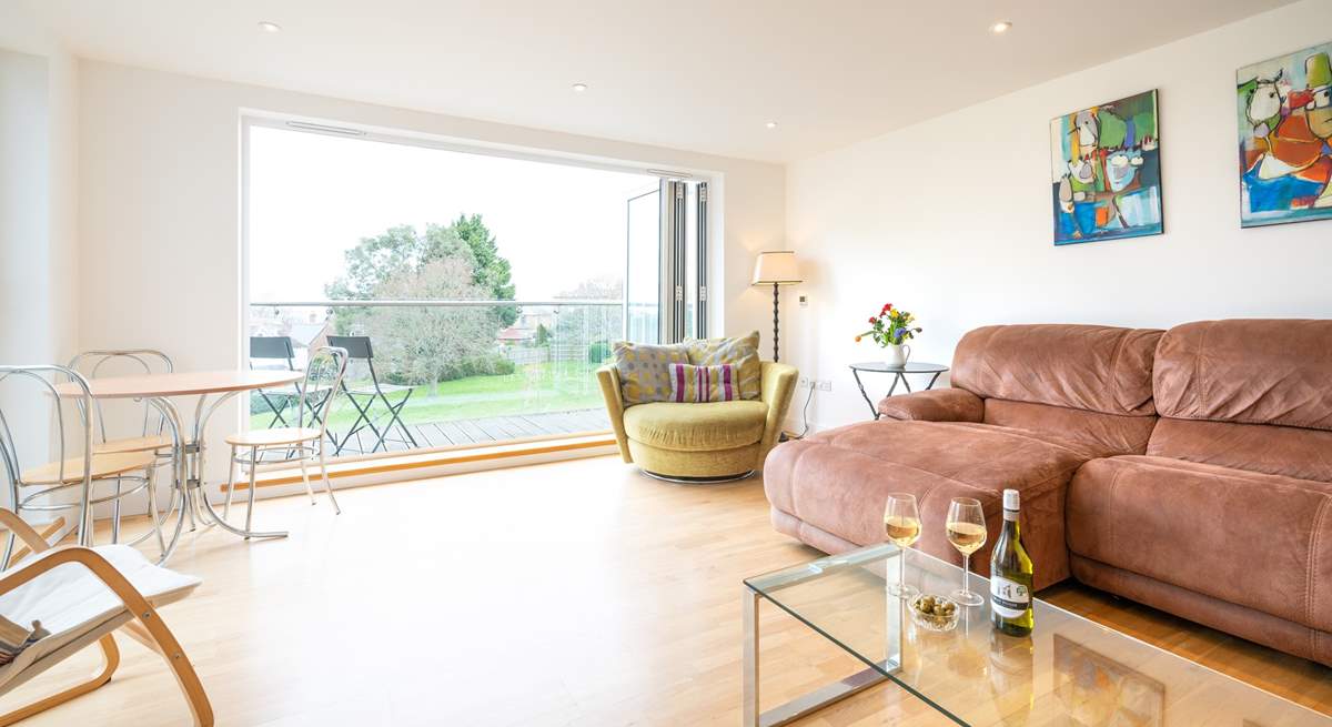 The spacious sitting-room, with generous seating, has doors leading to a large decked balcony.