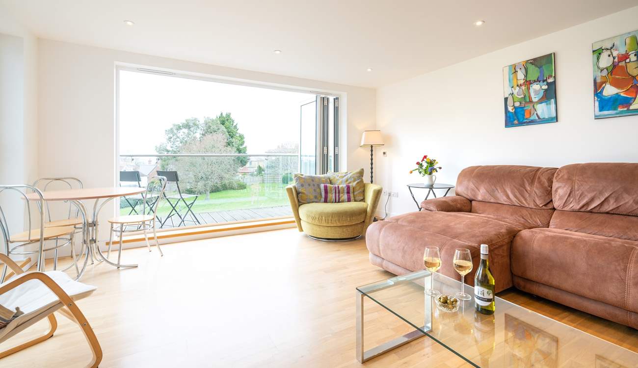 The spacious sitting-room, with generous seating, has doors leading to a large decked balcony.