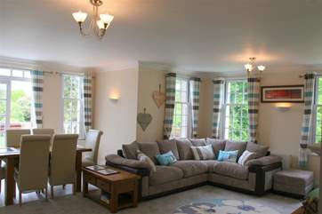 The comfortable living and dining area enjoys lovely views across the leafy grounds.