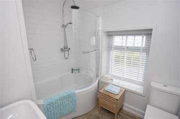 The modern white bathroom suite has a power shower.