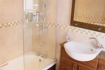 The bathroom has a fitted shower overhead.