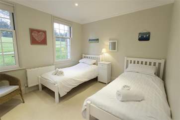 The bright twin bedroom overlooks the tennis court.
