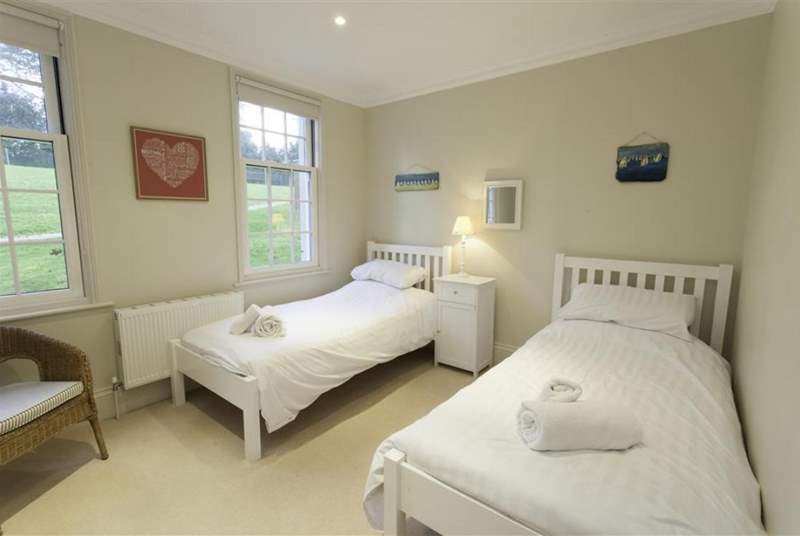The bright twin bedroom overlooks the tennis court.