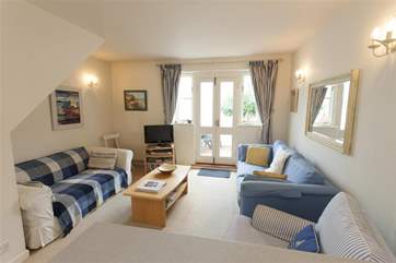 Airy open plan living-room and kitchen, with doors to a small enclosed patio.