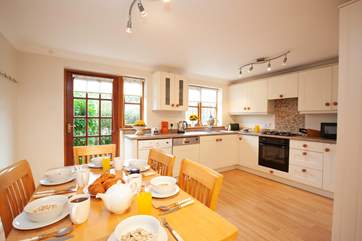 The bright kitchen leads to a leafy patio at the rear of the property.