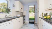 Large fully equipped kitchen with a door out to large lawned garden.