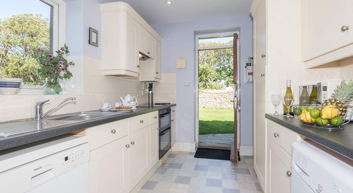 Large fully equipped kitchen with a door out to large lawned garden.