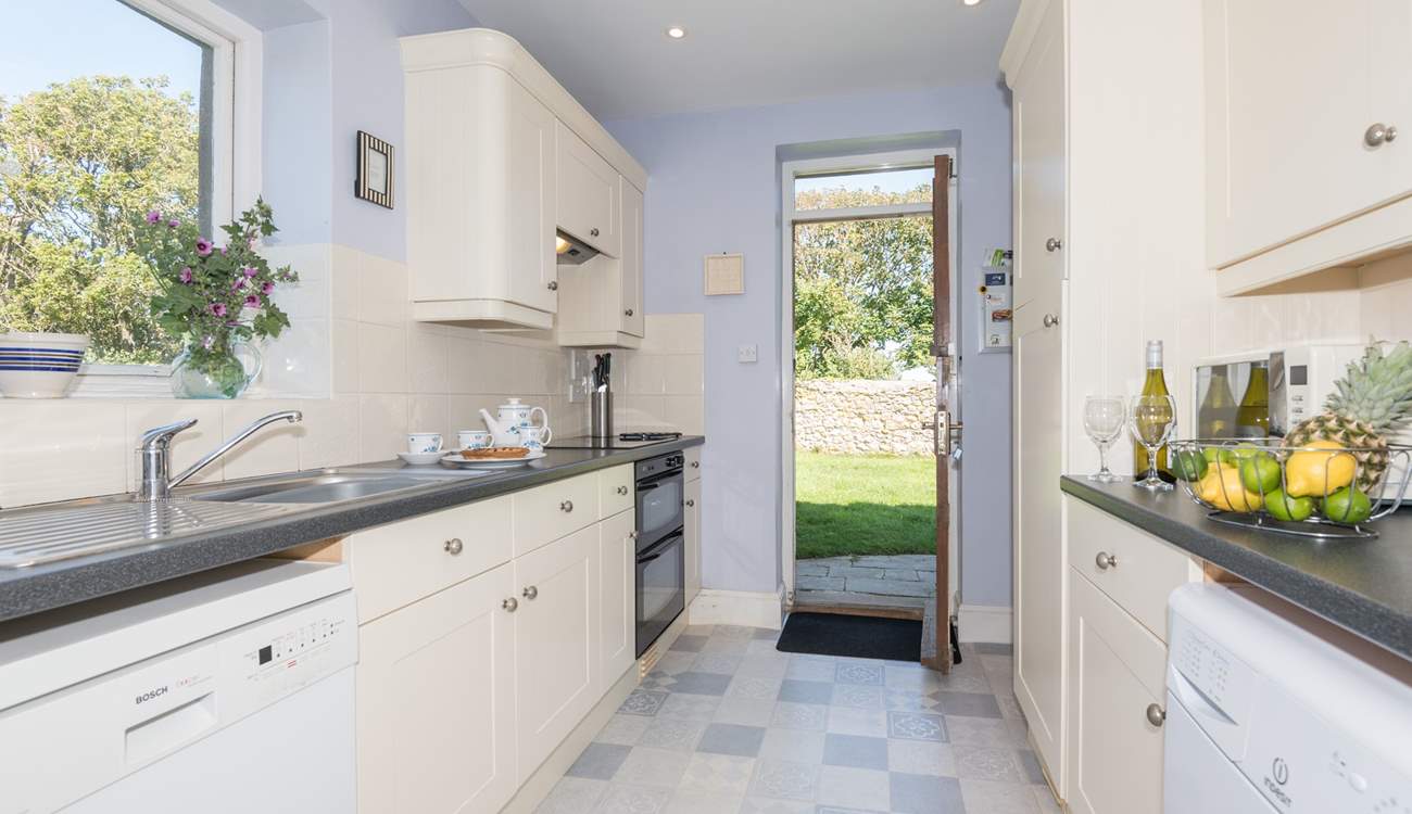 Large fully equipped kitchen with a door out to large lawned garden.