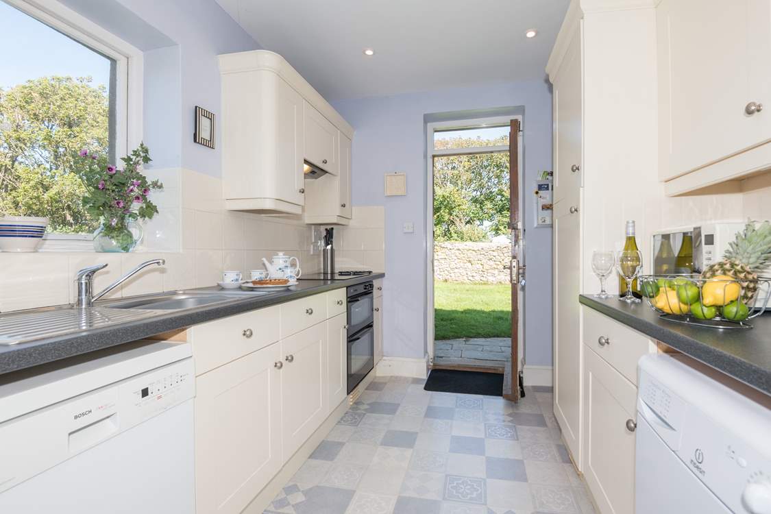 Large fully equipped kitchen with a door out to large lawned garden.