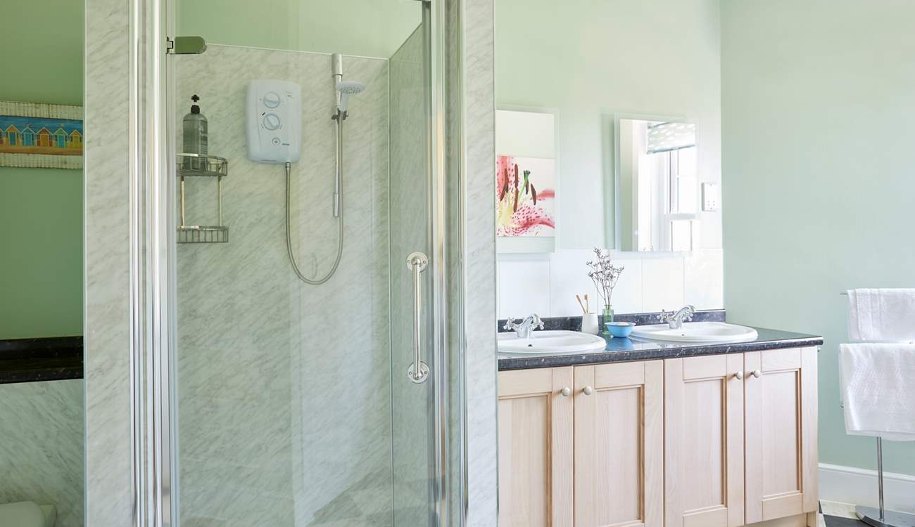 The light and airy bathroom provides a large shower cubicle and a separate bath.