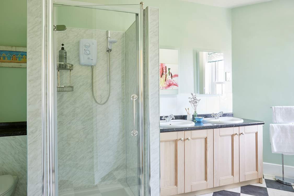 The light and airy bathroom provides a large shower cubicle and a separate bath.