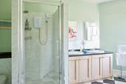 The light and airy bathroom provides a large shower cubicle and a separate bath.