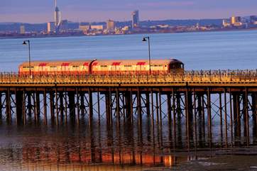 Watch the island train trundle its way up the Victorian pier to collect and drop off passengers for the catamaran.