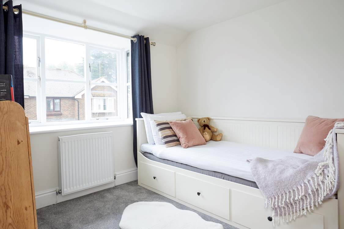 The comfortable single bedroom is cosy and full of natural light.