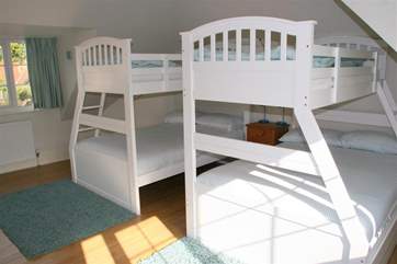 The family bedroom on the first floor is incredibly spacious, offering flexible sleeping quarters that would suit adults and children alike.