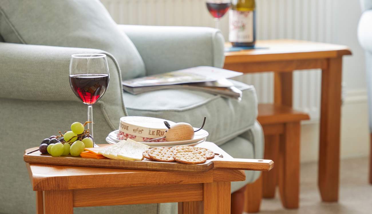 Simple pleasures: wine and nibbles by the cosy armchair.
