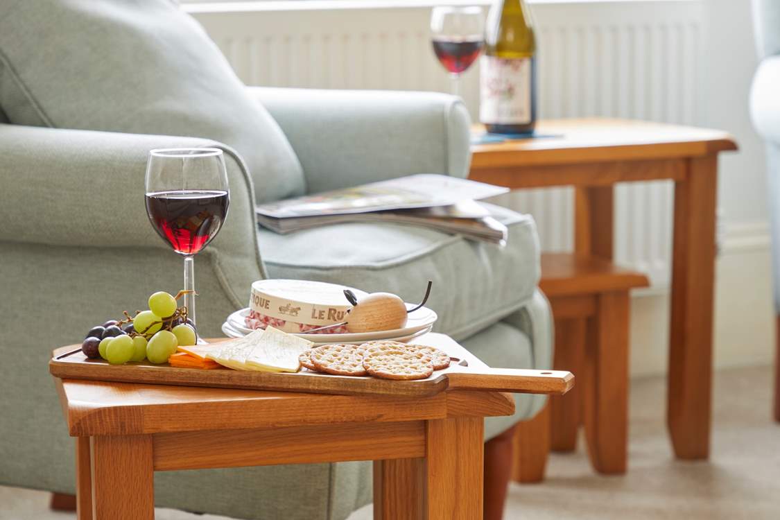 Simple pleasures: wine and nibbles by the cosy armchair.