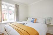 Soft textures and natural light in the ground floor bedroom.