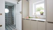 The utility-area with an additional integrated fridge/freezer, washing machine and drier leading into the downstairs shower-room.