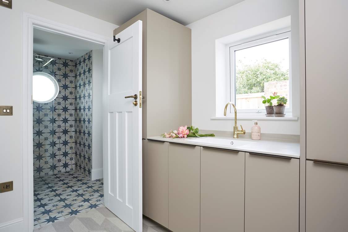 The utility area with an additional integrated fridge/freezer, washing machine and drier leading into the downstairs shower-room.